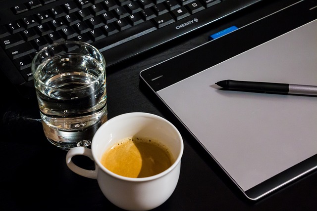 work-1699510_640 Computer Keyboard, Digital Drawing Pad, Cup of Coffee and Cup of Water